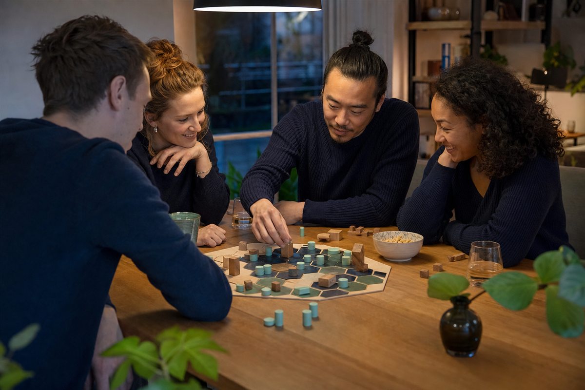 Vier vrienden spelen geconcentreerd een bordspel aan een houten tafel